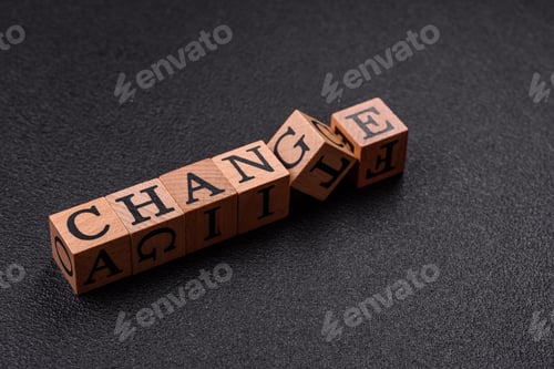 Preview: The inscription chance or change with wooden cubes on a dark concrete background