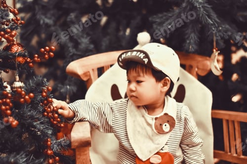 Preview: Toddler decorating a Christmas tree with berries