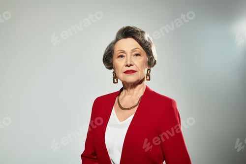 Preview: A sophisticated woman in her 60s poses confidently in chic attire, radiating elegance and style.