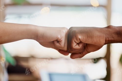 Preview: Closeup shot of two businesspeople fist bumping. Two unknown partners starting a new business toget