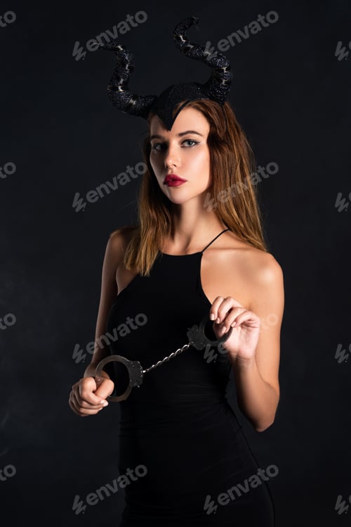 Preview: attractive woman with horns holding handcuffs on black