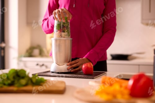 Preview: Close Up Of Woman In Kitchen Wearing Fitness Clothing Blending Fresh Ingredients For Healthy Drink