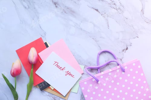 Preview: thank you message on a paper note tulip flower on tiles background