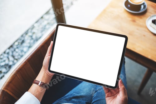Preview: A business woman holding black tablet pc with blank white desktop screen in cafe