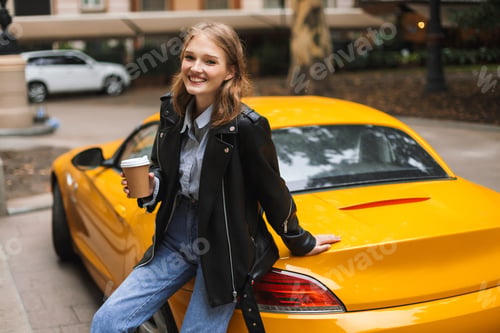 Preview: Beautiful smiling girl in leather jacket leaning on yellow sport