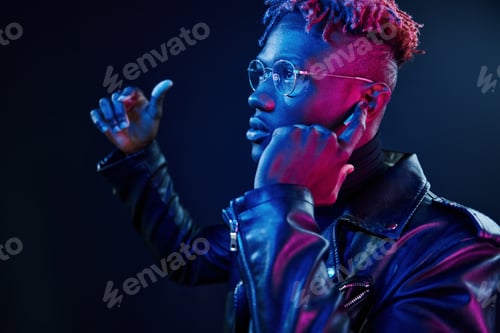 Preview: Listening to the music. Futuristic neon lighting. Young african american man in the studio