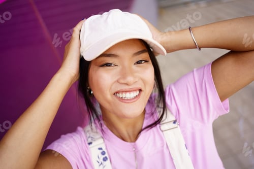Preview: Asian woman touching head and smiling