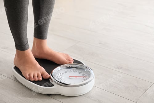 Preview: Woman standing on scales indoors, space for text. Overweight problem