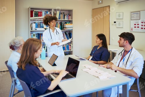 Preview: Medical team meeting discussing patient cases in hospital conference room