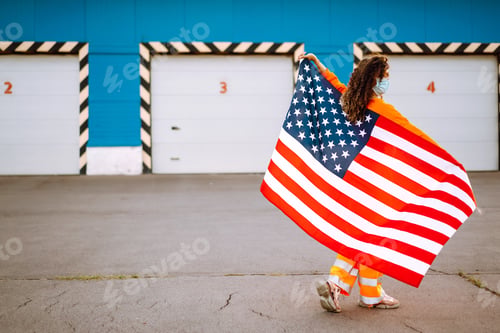 Preview: African American woman with medical face mask posing with american flag. Covid-2019.