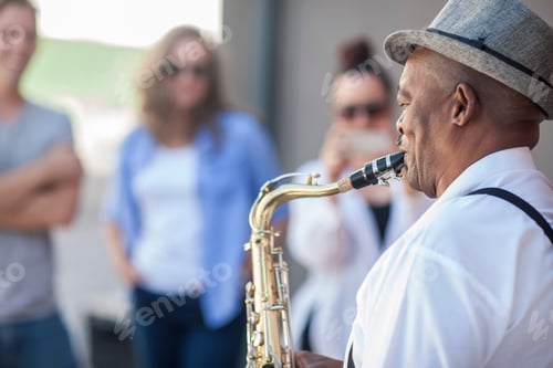 Preview: Street musician, playing saxophone, entertaining pedestrians