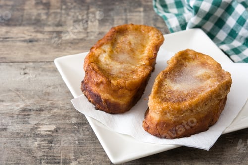 Preview: French toast with sugar and cinnamon resting on a white plate