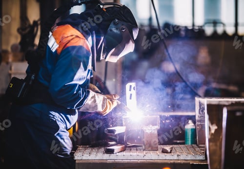 Preview: Worker welding in oxygen mask in a factory