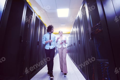 Preview: engineer showing working data center server room to female chief
