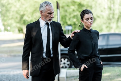 Preview: bearded man touching hand of attractive woman with hands in pockets