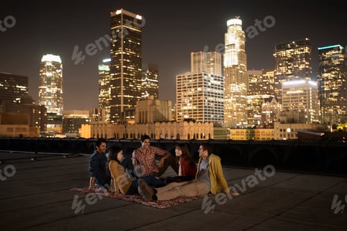 Preview: A group of friends gathered on a rooftop overlooking a city lit up at night.
