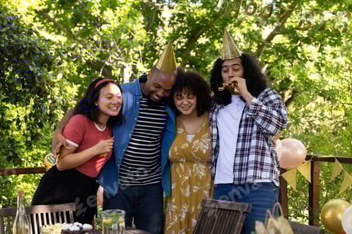 Visualização: Amigos comemorando ao ar livre usando chapéus de festa e sorrindo de alegria