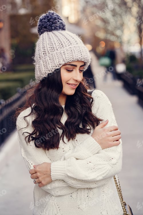 Preview: Cute brunette in a white sweater in a city