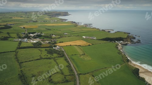 Preview: Irish aerial green fields landscape shot: road along meadows. Ireland wide plants and farms
