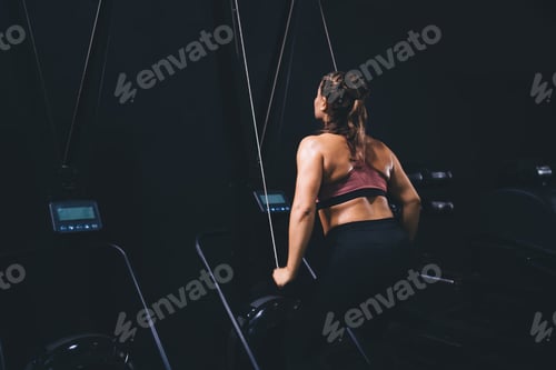 Preview: Caucaisan athletic girl engaged in pectoral exercise machine in sportive gym studio,