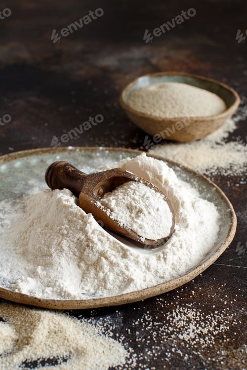 Preview: Raw fonio flour and seeds with a spoon on dark background