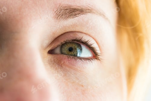 Preview: Closeup shot of a young ginger woman's hazel eye looking into the distance