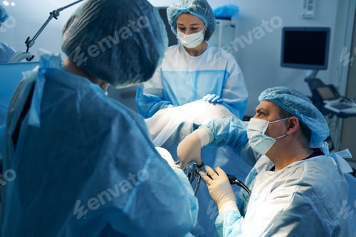 Preview: Surgeon with nurses doing operation with laparoscopic equipment