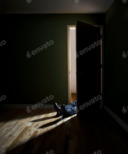 Preview: Businessman lying in doorway of dark room