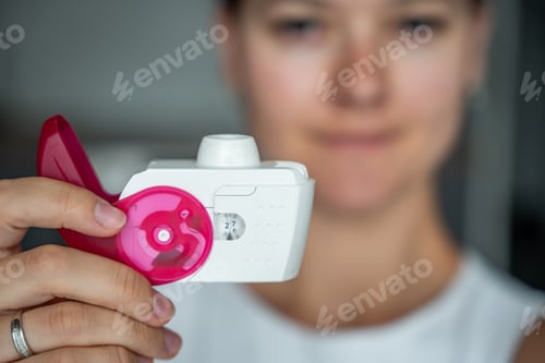 Preview: Close up view of woman holding medicine dry powder inhaler for treatment asthma or COPD diseases
