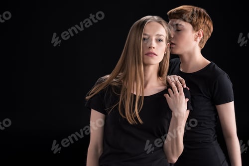 Preview: Half-length shot of young woman touching her girlfriend on shoulder and smelling her hair