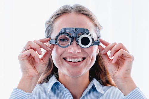 Preview: Young smiling girl is fitting special ophthalmic glasses to check up her