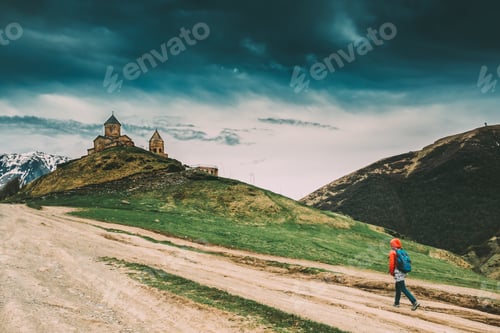 Preview: Stepantsminda, Gergeti, Georgia. Woman Walking Near Trinity Chur