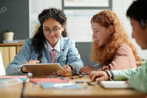 Preview: Two cute intercultural schoolgirls preparing presentation of English words