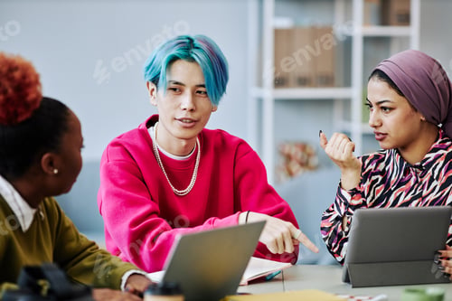 Preview: Young Asian man talking to creative team in meeting