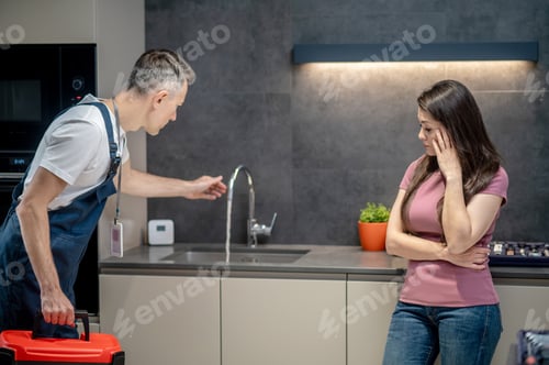 Preview: Man stretching hand to water tap and pensive woman