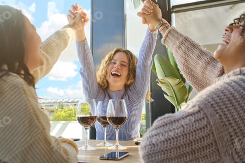 Preview: Laughing girlfriends at restaurant with wine