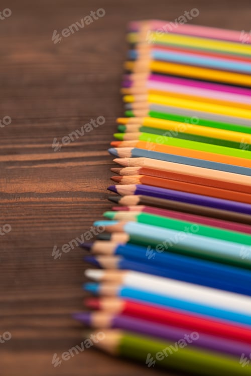 Preview: Set of watercolor pencils on brown wooden. Side view, selective focus