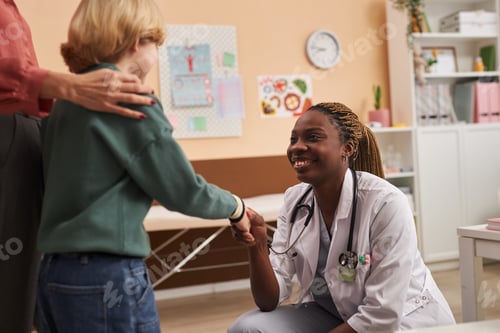 Preview: Young Black Woman as Pediatrician Greeting Boy in Clinic