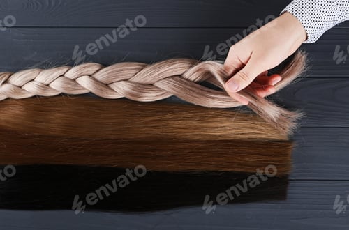 Preview: The male hand holds sections of hair for extension.