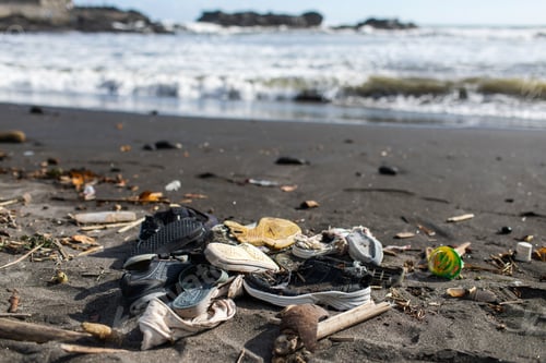 Preview: Environmental pollution. Heap of used rubber shoes on the beach in Bali, Indonesia.