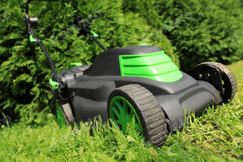 Preview: Cutting green grass with lawn mower in garden