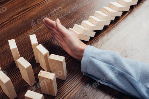 Preview: cropped view of woman at desk preventing wooden blocks from falling