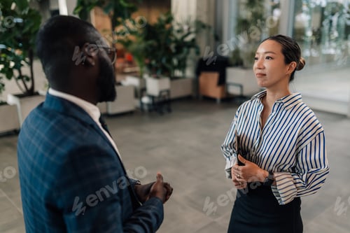 Preview: Businesspeople discussing strategy in modern office environment