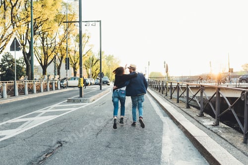 Preview: Rear view of couple running by city canal