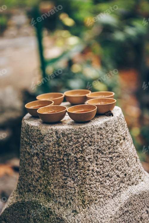 Preview: Beautiful clay cups elegantly placed on a stone base in a serene natural setting