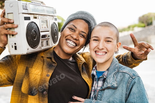 Preview: Happy multiracial girls having fun listening to music with vintage boombox stereo outdoor