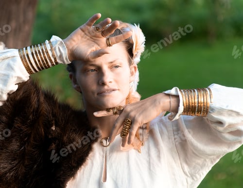 Preview: Harmonious calm woman with fur, feather ornaments, gilded copper rings and bracelets