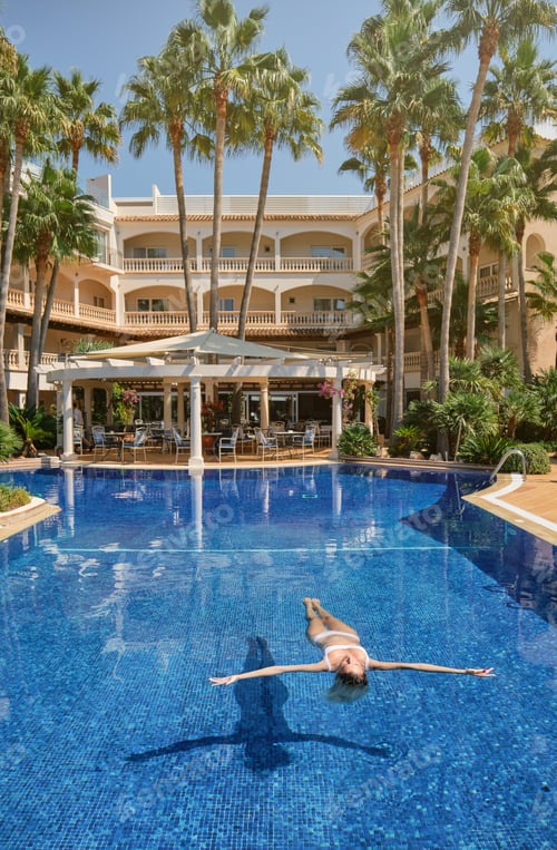 Preview: Woman swimming in clean pool in hotel