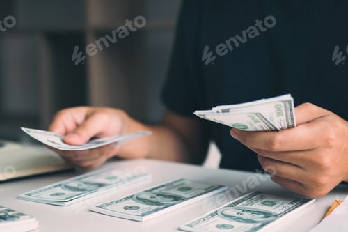 Preview: Asian men are holding banknotes in cash and placed on the table with the idea of saving money.