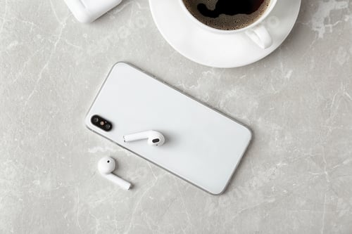 Preview: Flat lay composition with wireless earphones and mobile phone on light grey marble table